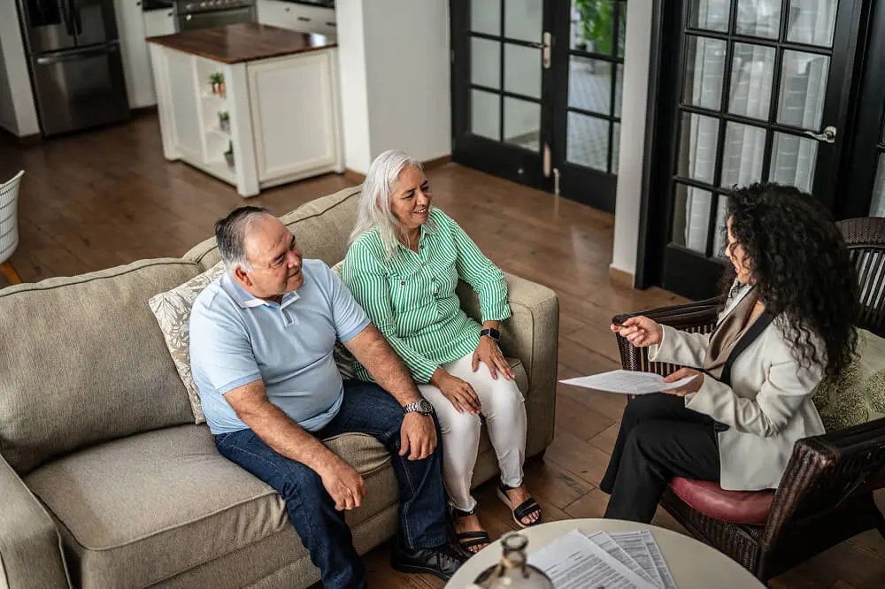 Couple discussing with advisor in living room.